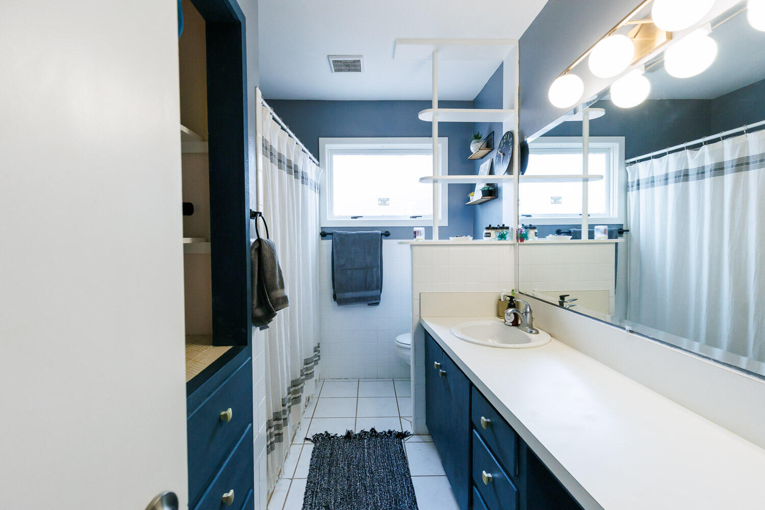 2718 55th Street Lubbock, TX 79413 - Photo 34 of 58 a bathroom with a sink a mirror and a bathtub