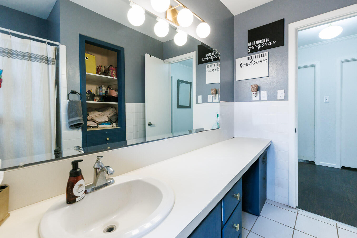 2718 55th Street Lubbock, TX 79413 - Photo 35 of 58 a bathroom with a sink and a mirror