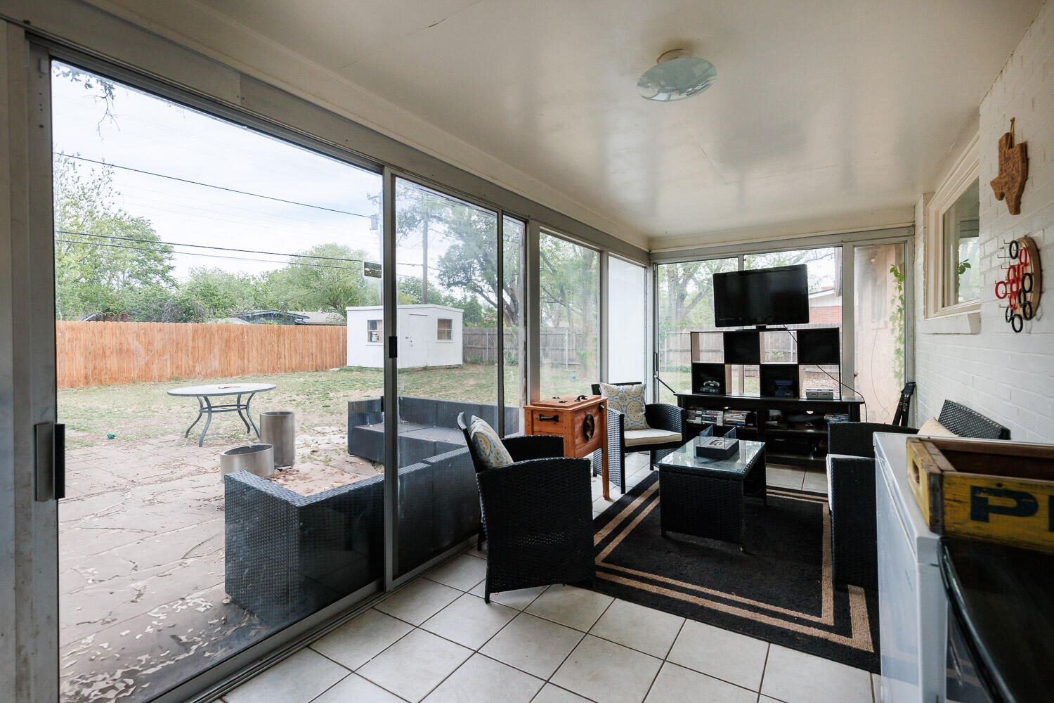 2718 55th Street Lubbock, TX 79413 - Photo 48 of 58 a living room with patio furniture and a floor to ceiling window