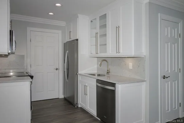 a kitchen with stainless steel appliances granite countertop a refrigerator and a stove top oven