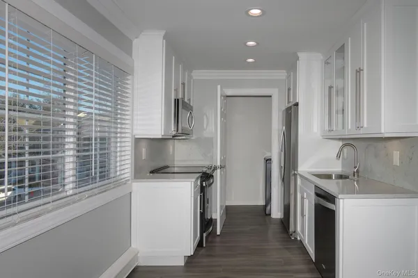 a kitchen with a sink cabinets stainless steel appliances and a window