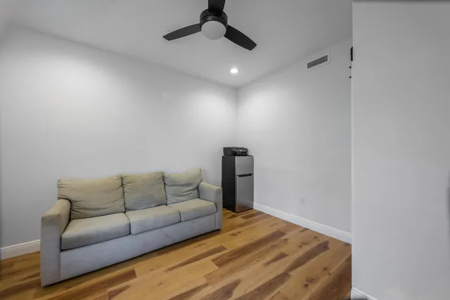 a living room with furniture and a ceiling fan