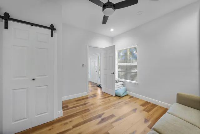 a view of empty room with wooden floor and fan