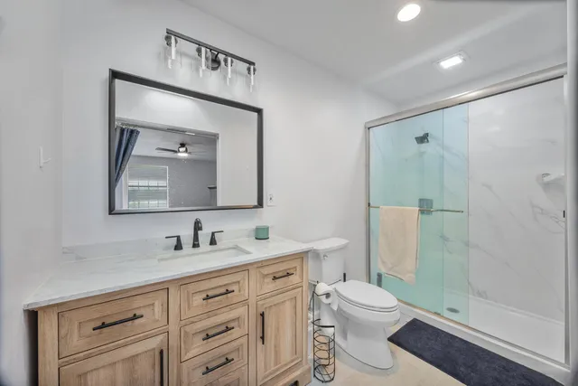 a bathroom with a toilet sink shower and mirror