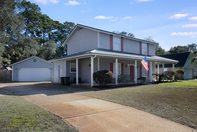 a view of a house with a patio and a yard