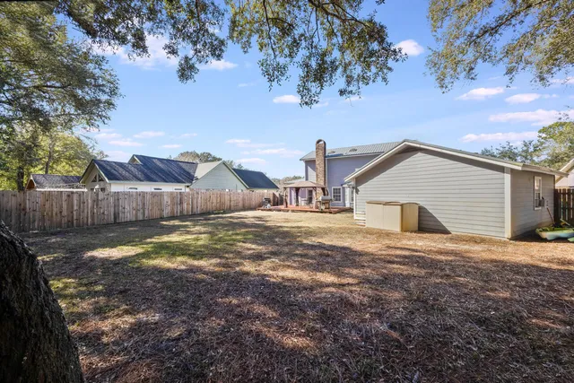 a view of backyard with wooden fence and a large tree