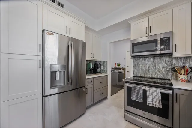 a kitchen with stainless steel appliances granite countertop a refrigerator stove and sink