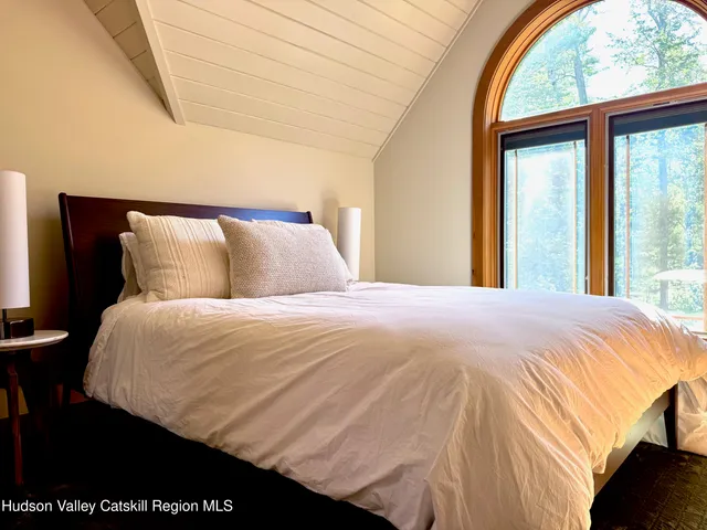 a bedroom with a bed and a large window