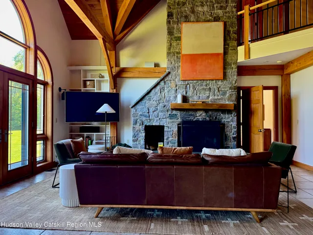 a living room with furniture a fireplace and a large window