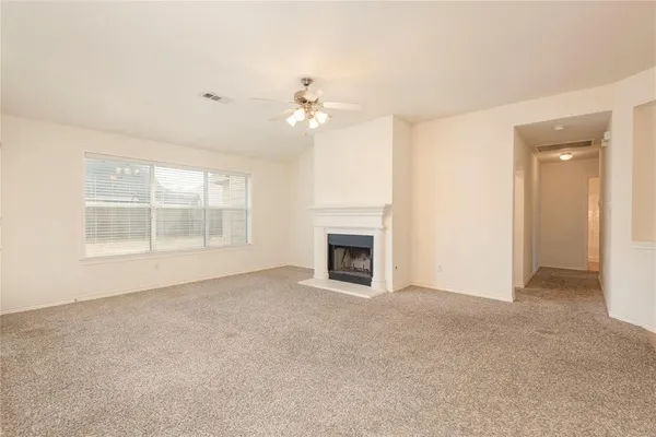an empty room with windows and fireplace