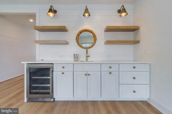 an empty room with wooden floor ceiling fan and window