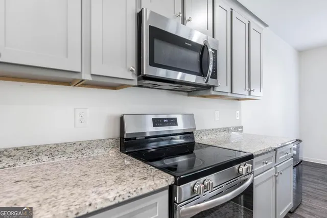 a kitchen with stainless steel appliances granite countertop a stove microwave and sink
