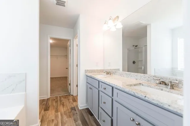 a spacious bathroom with a granite countertop sink and a mirror