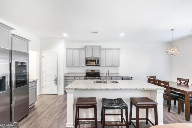 a dining hall with stainless steel appliances granite countertop a dining table and chairs