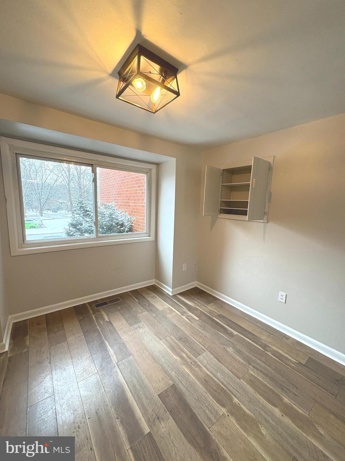 9432 Merryrest Road Columbia, MD 21045 - Photo 11 of 47 a view of an empty room with wooden floor and a window