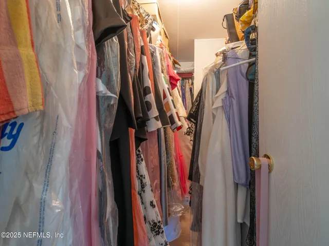 a view of walk in closet with clothes
