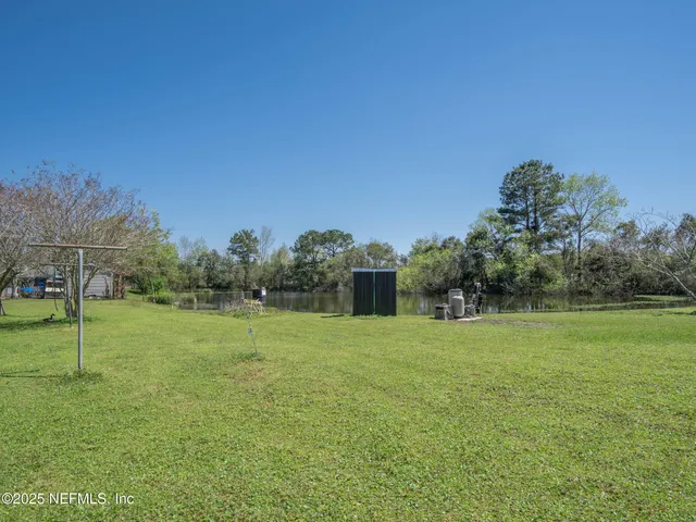 a white house with a big yard and large trees