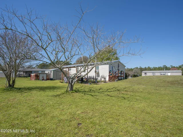 a view of a house with backyard and sitting area