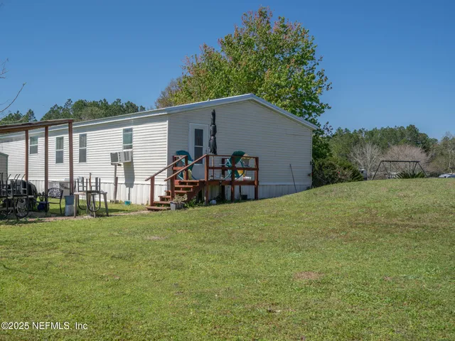 a view of a house with backyard and trees