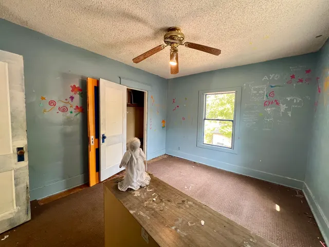 a view of an empty room with a fireplace and a window