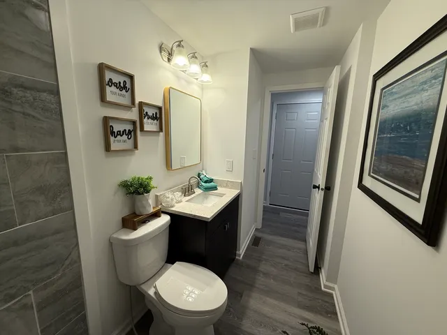 a bathroom with a toilet a sink and mirror