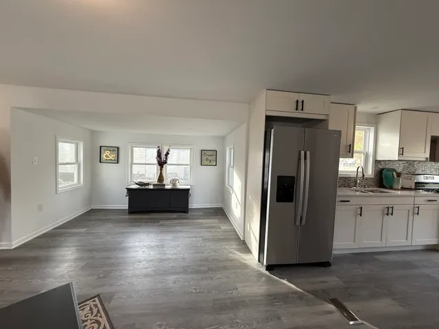 a kitchen with a refrigerator and white cabinets