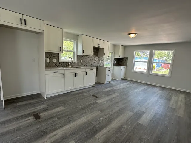 a kitchen with granite countertop a stove a sink and a refrigerator