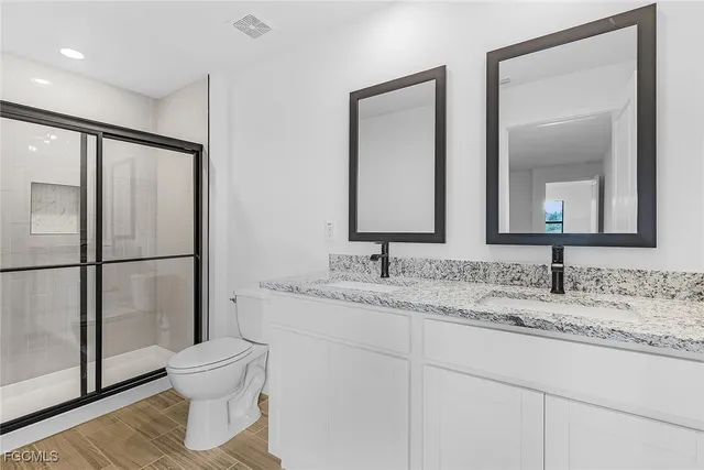 a bathroom with a toilet sink vanity and mirror