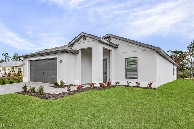 a front view of a house with a garden and yard