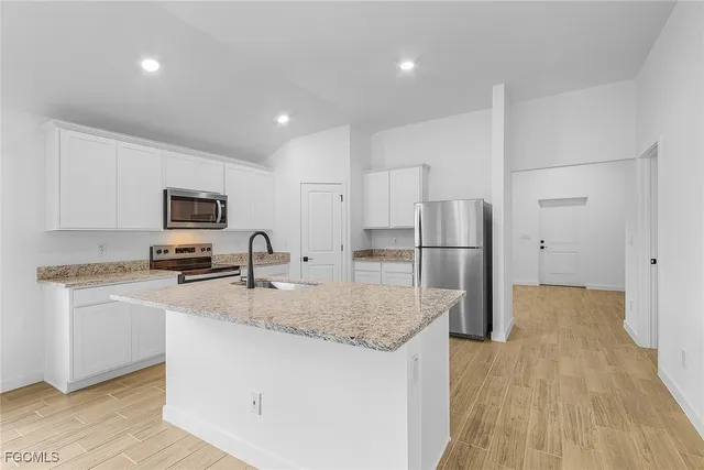 a kitchen with stainless steel appliances granite countertop a refrigerator sink and microwave