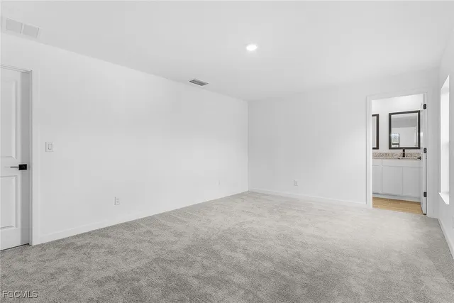 an empty room with a cabinet and mirrors