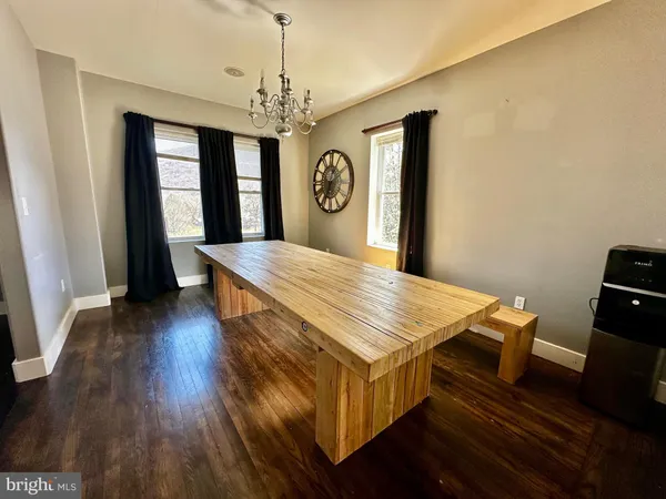 a living room with a table chairs and wooden floor