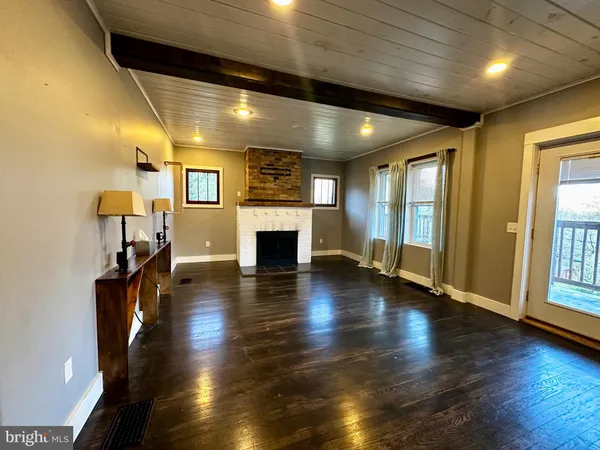 an empty room with wooden floor and fireplace
