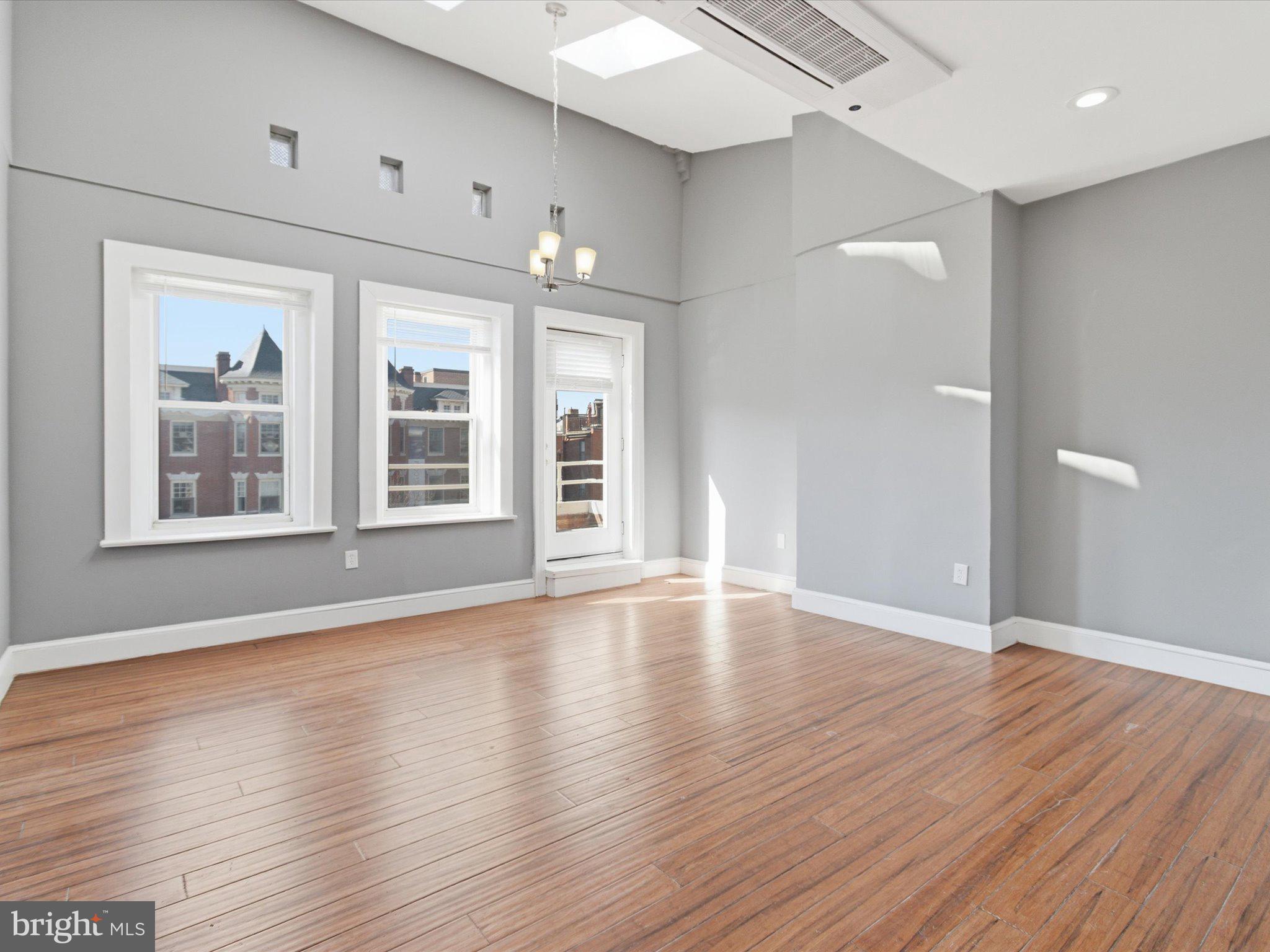2617 13th Street Northwest, Unit PH Washington, DC 20009 - Photo 11 of 12 a view of an empty room with wooden floor and windows