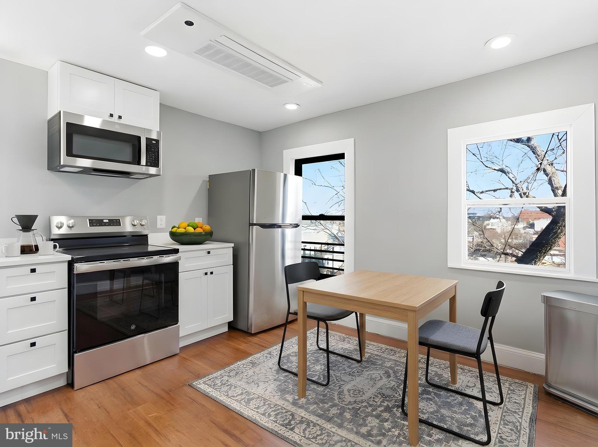 2617 13th Street Northwest, Unit PH Washington, DC 20009 - Photo 2 of 12 a kitchen with stainless steel appliances kitchen island granite countertop a stove a sink and a refrigerator
