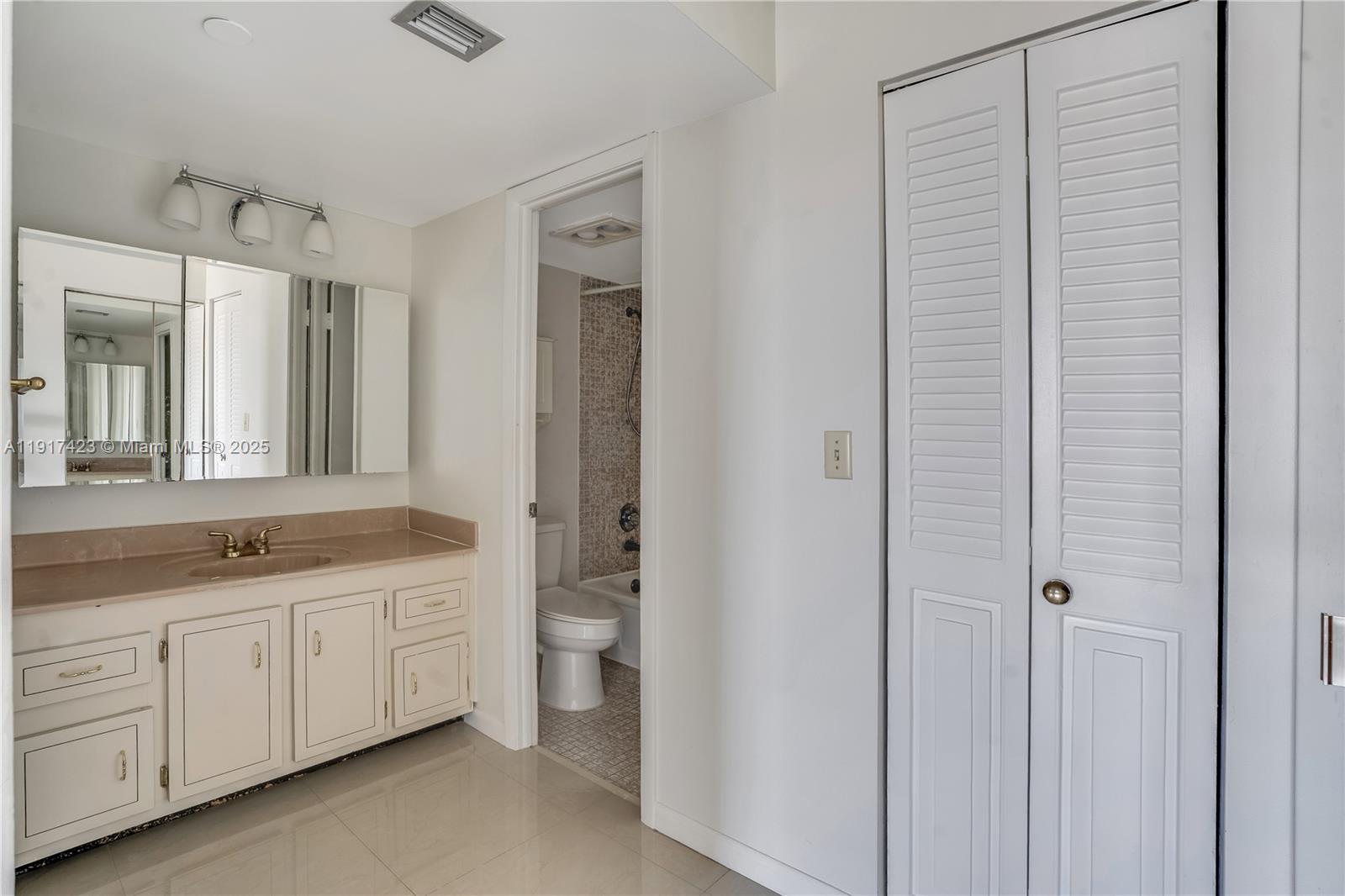 1200 St Charles Place, Unit 716 Pembroke Pines, FL 33026 - Photo 14 of 29 a bathroom with a double vanity sink a toilet and a mirror