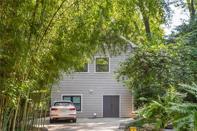 a living room with couches a flat screen tv and a table with wooden floor