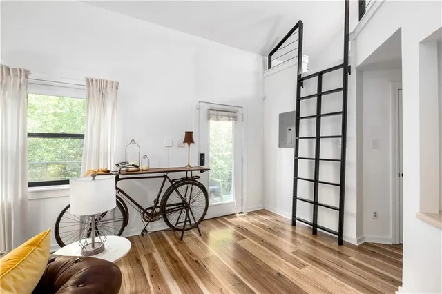 a kitchen with stainless steel appliances a stove a sink dishwasher a refrigerator and white cabinets with wooden floor