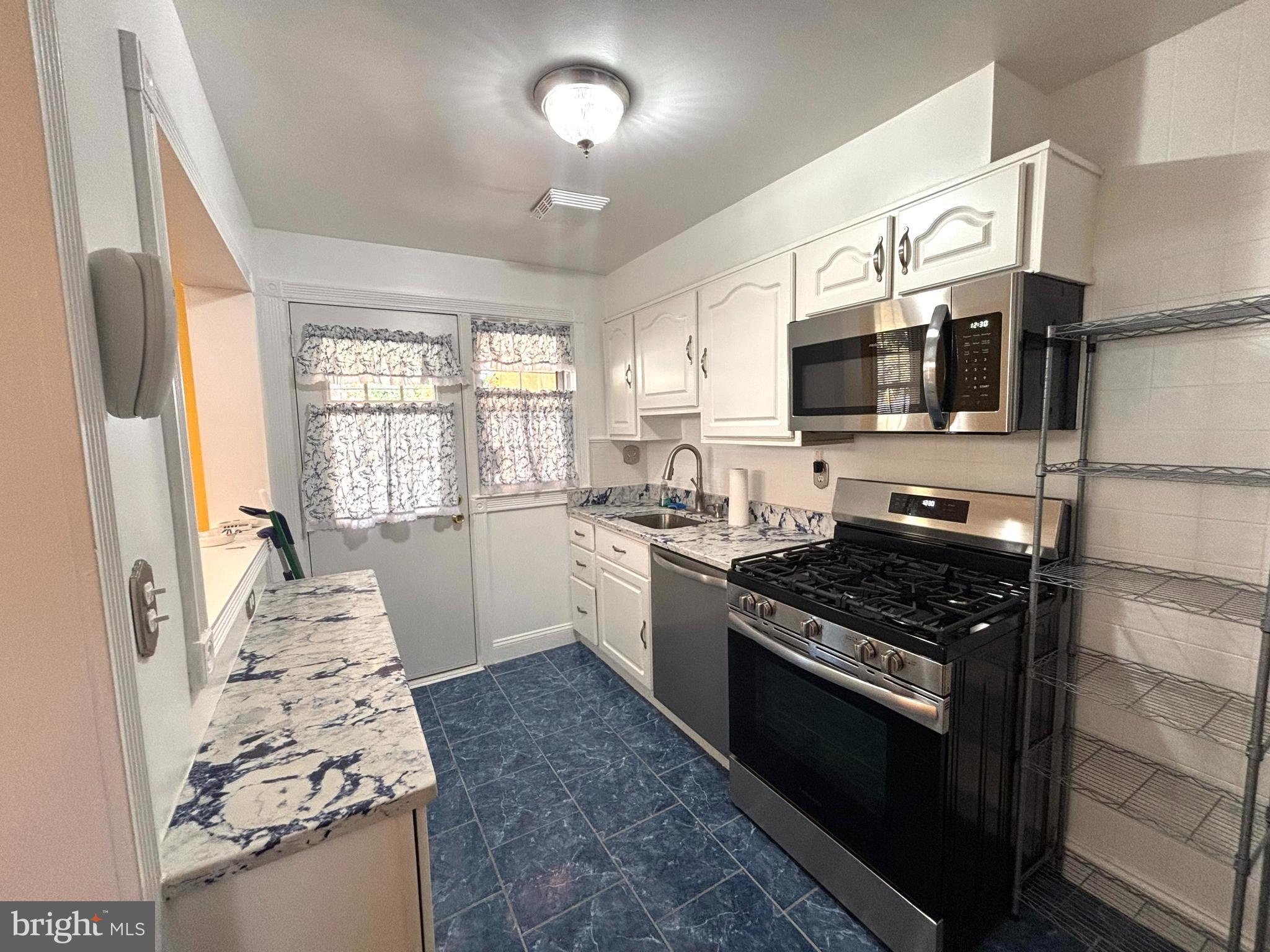 6527 Hilltop Avenue Baltimore, MD 21206 - Photo 12 of 32 a kitchen with a stove and a microwave