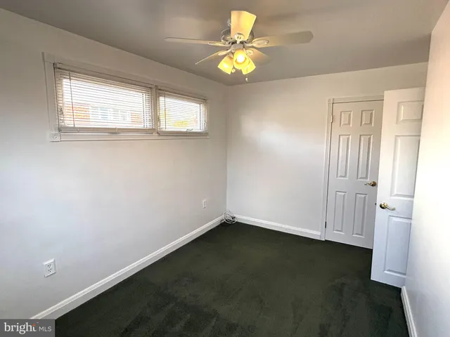 an empty room with a window and a chandelier