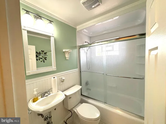 a bathroom with a sink toilet a mirror and shower