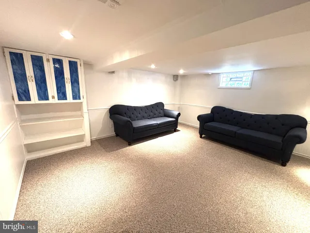 a living room with furniture and a ceiling fan