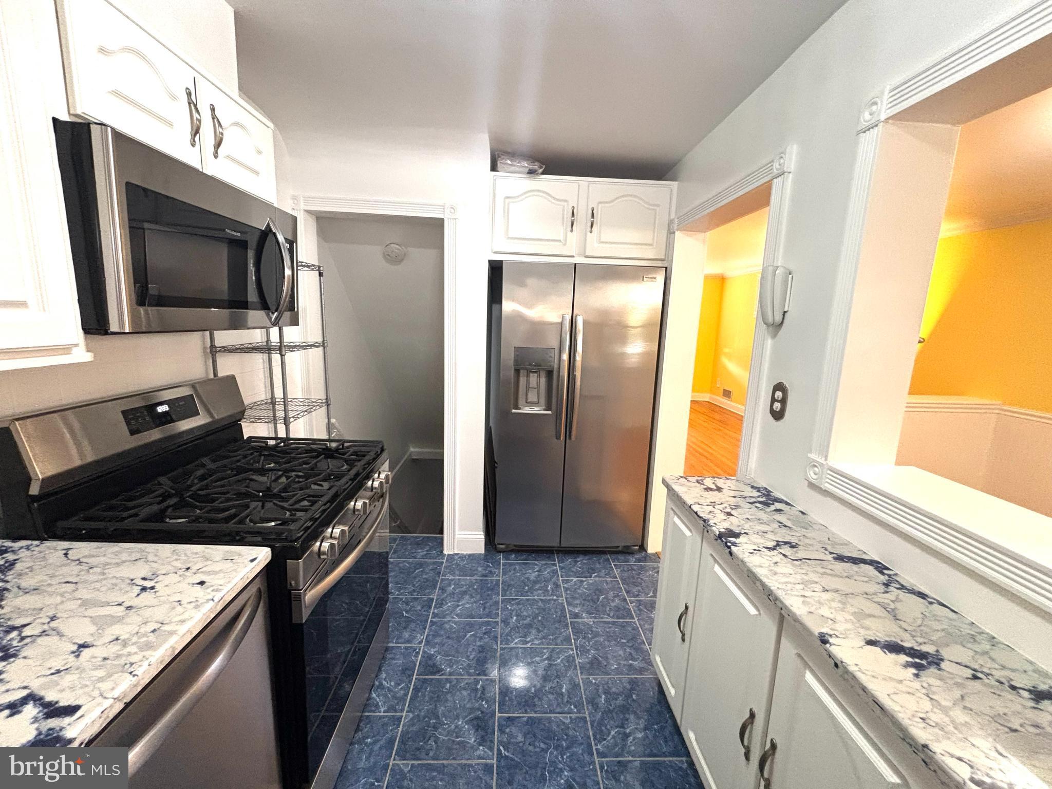 6527 Hilltop Avenue Baltimore, MD 21206 - Photo 8 of 32 a kitchen with a stove microwave and refrigerator