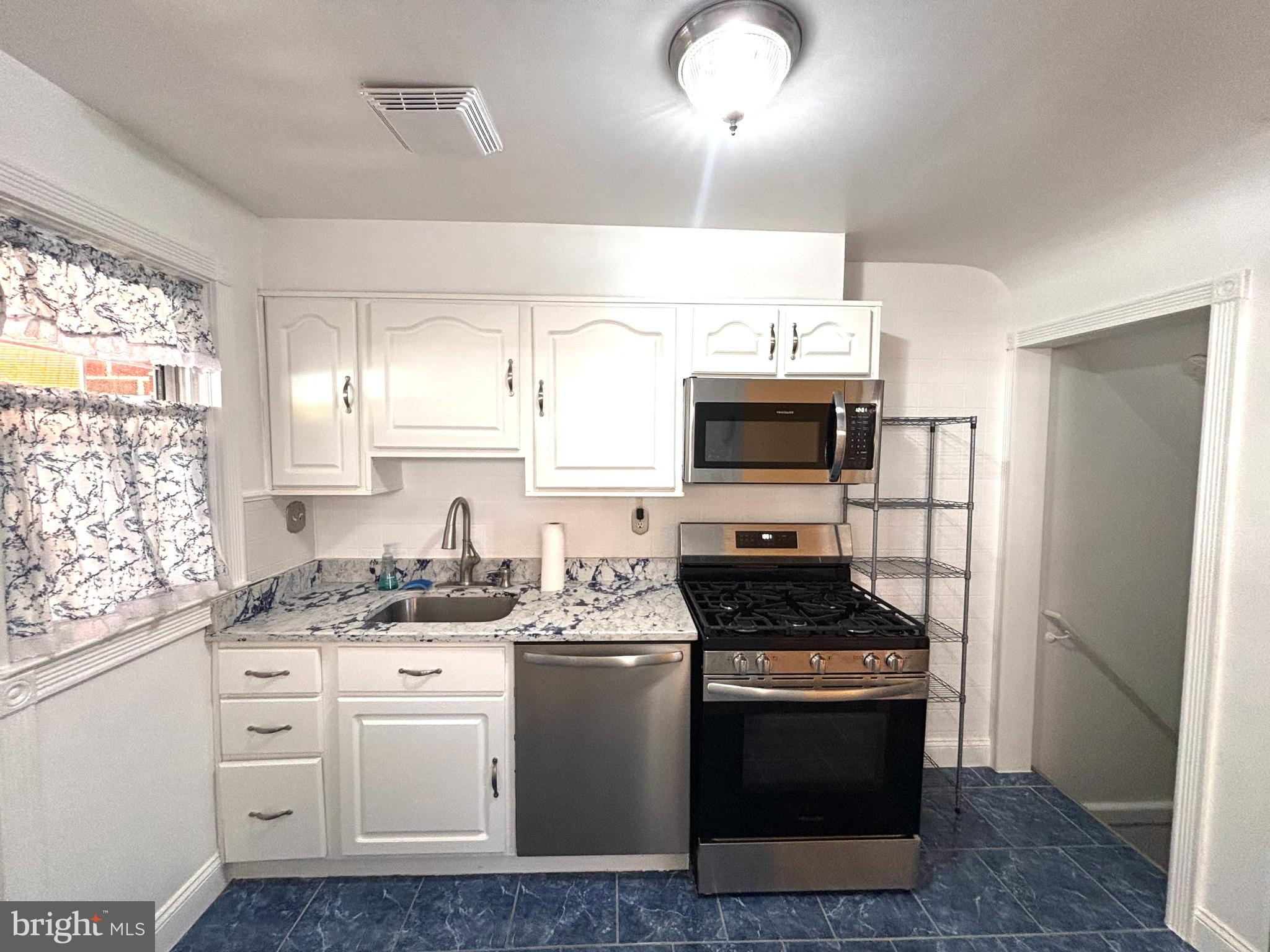 6527 Hilltop Avenue Baltimore, MD 21206 - Photo 9 of 32 a kitchen with stainless steel appliances kitchen island granite countertop a stove and a sink