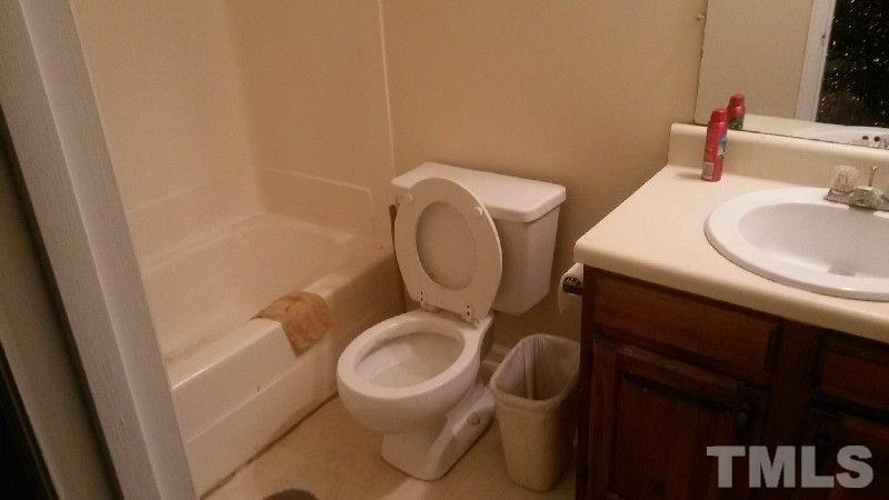 6621 English Ivy Lane Raleigh, NC 27615 - Photo 3 of 17 a bathroom with a toilet a sink and a mirror