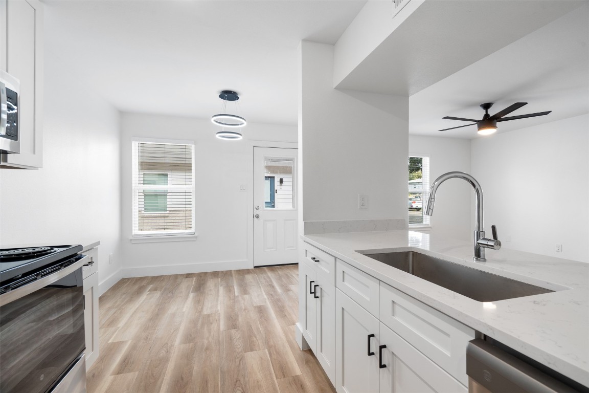 1901 Hearthstone Drive, Unit D Austin, TX 78757 - Photo 12 of 30 a kitchen with a sink and a stove top oven