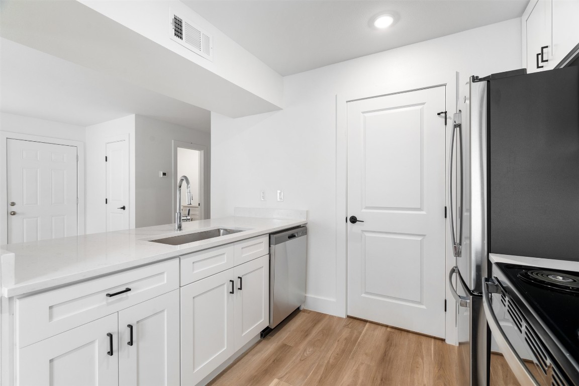 1901 Hearthstone Drive, Unit D Austin, TX 78757 - Photo 13 of 30 a view of a kitchen with a sink wooden floor and staircase