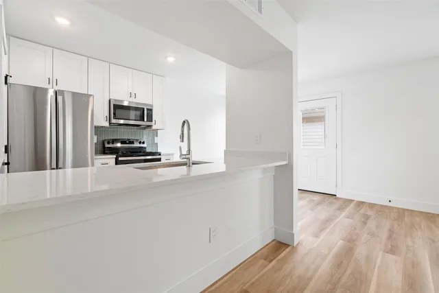 a kitchen with stainless steel appliances a refrigerator and a stove top oven