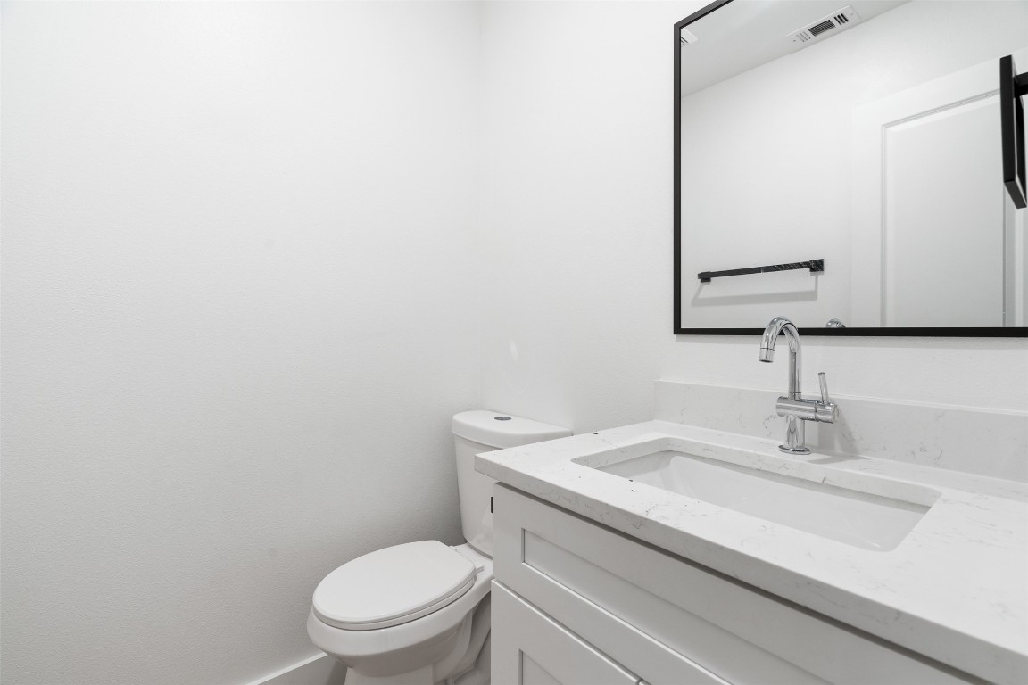 1901 Hearthstone Drive, Unit D Austin, TX 78757 - Photo 22 of 30 a bathroom with a toilet a sink and mirror
