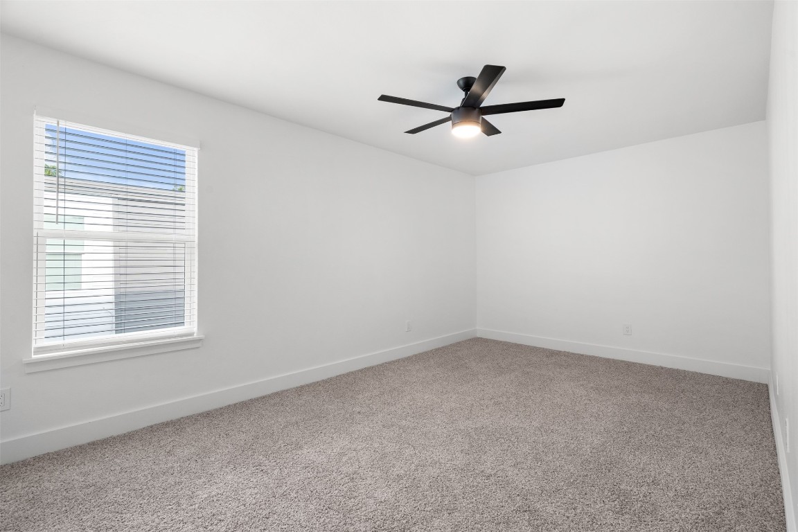 1901 Hearthstone Drive, Unit D Austin, TX 78757 - Photo 26 of 30 an empty room with a window and a fan